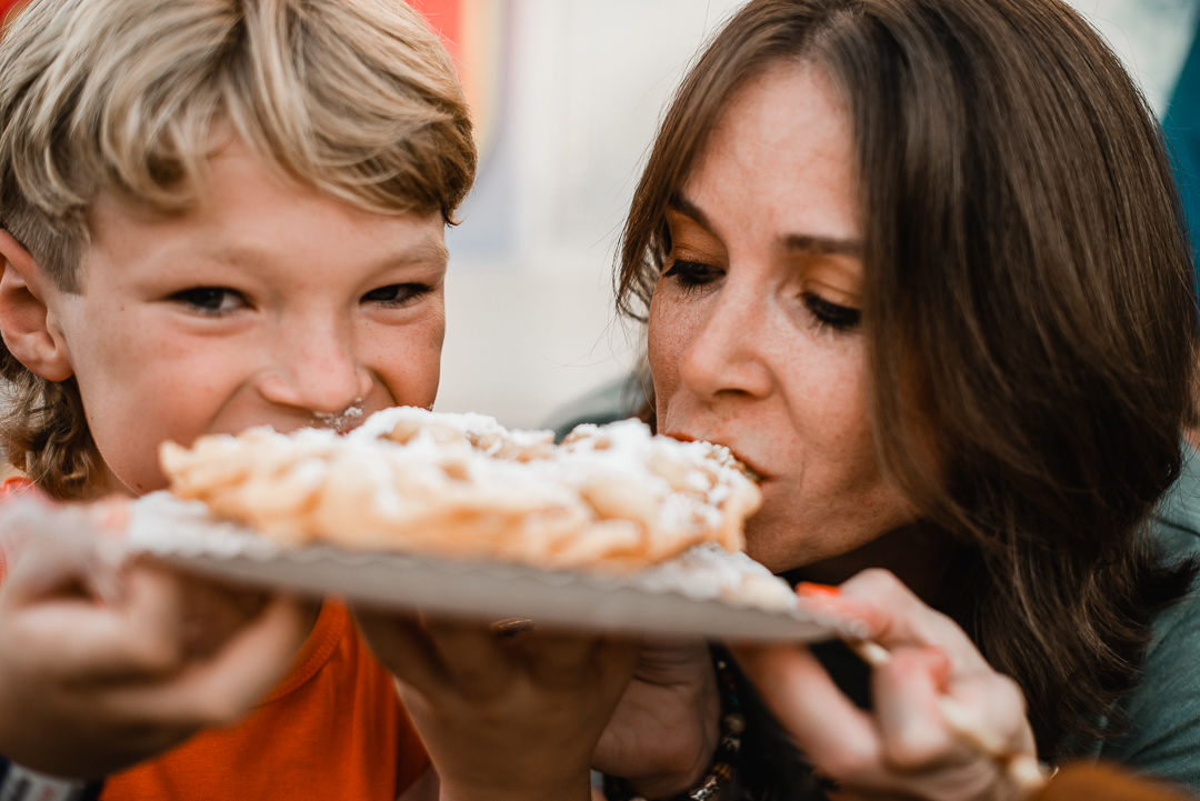 Omaha family enjoying funnel cake at Sarpy County Fair during storytelling session with Melissa Lindquist Photography.