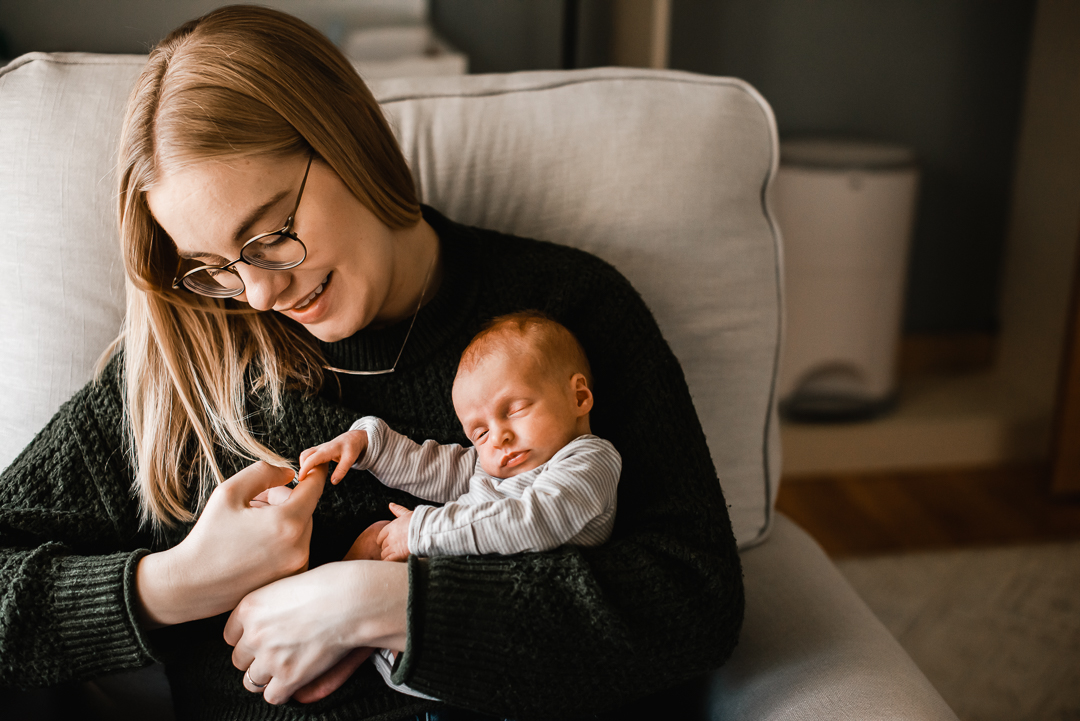 New mom memorizes her new baby during a newborn photography session with Melissa Lindquist Photography in Omaha.