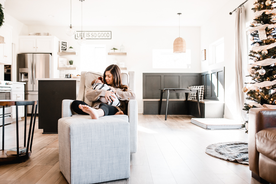 Mom cuddles with her newborn baby in Omaha during her session with Melissa Lindquist Photography.