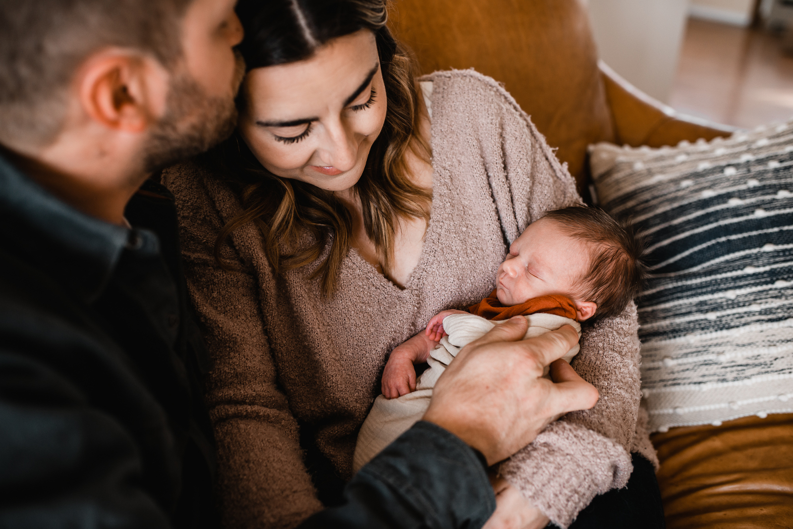 Omaha family cuddling with their newborn during their in-home newborn session with Melissa Lindquist Photography.