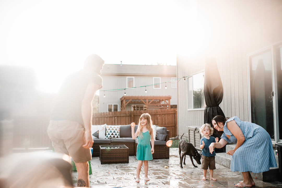 Parents and children laughing together during an in-home family session in Omaha