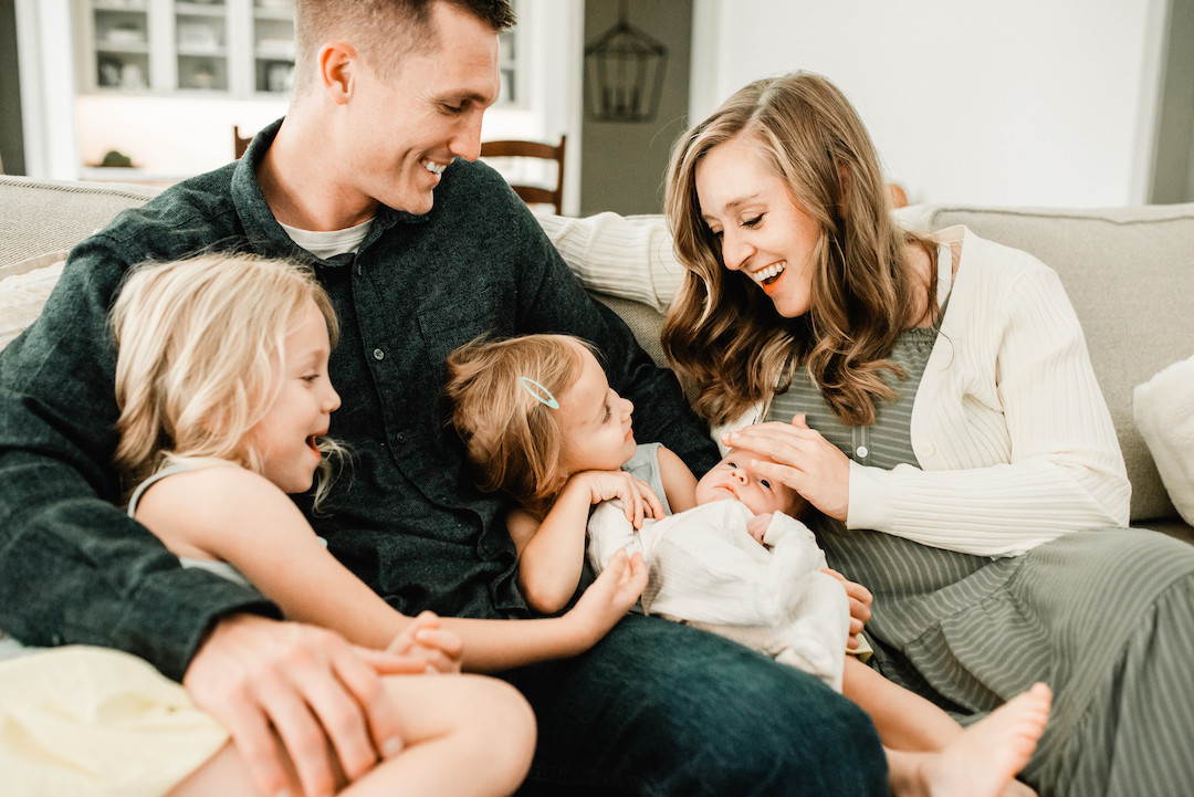 New parents bonding with their newborn during an in-home photography session in Omaha