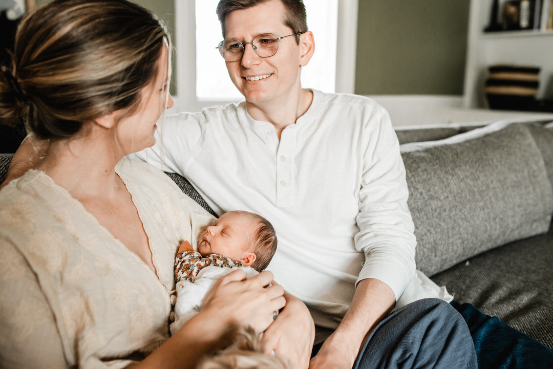 New parents bonding with their newborn during an in-home photography session in Omaha