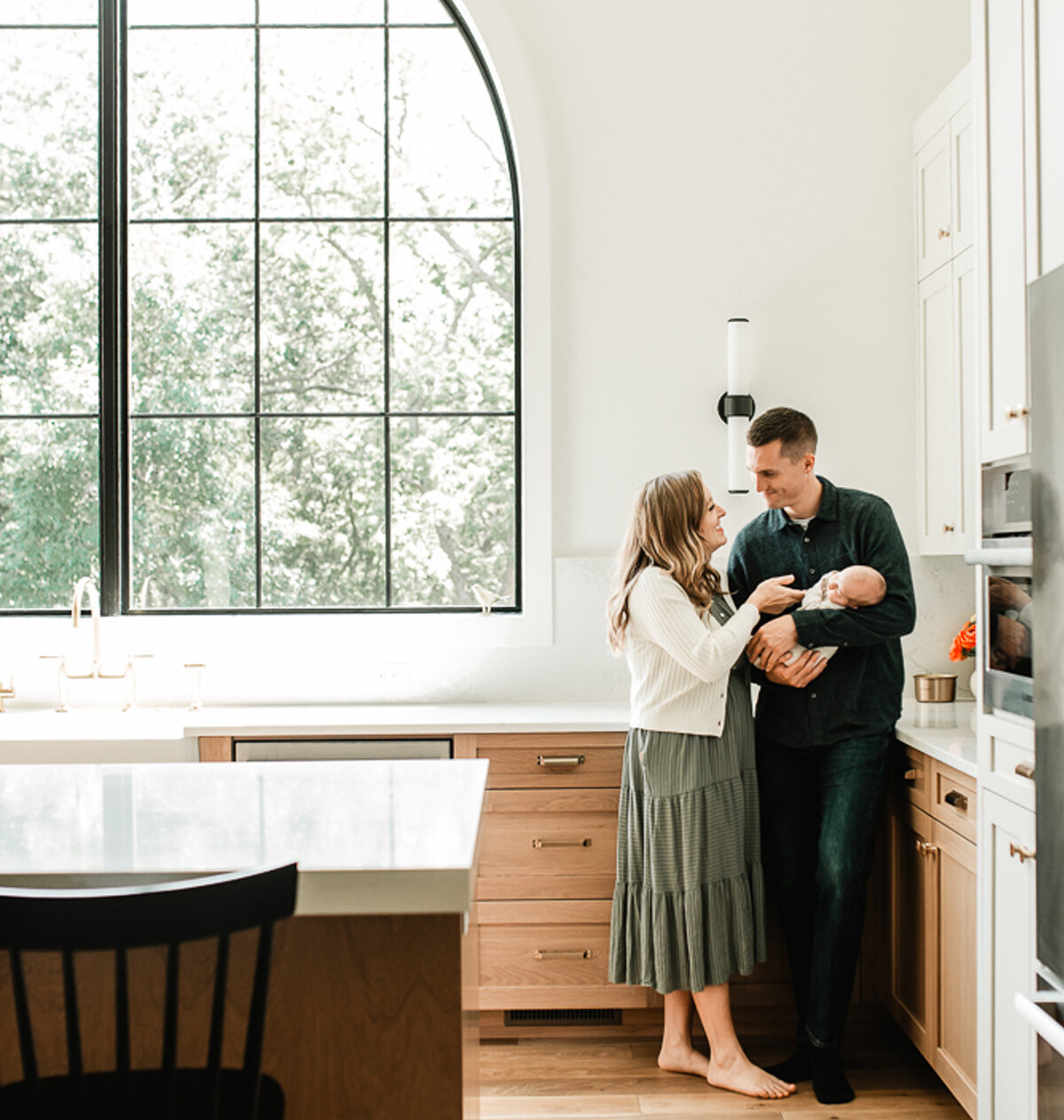 Mom and dad snuggling their baby during an in-home newborn session with Melissa Lindquist Photography.