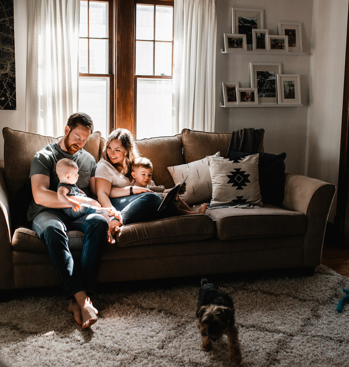 Family snuggling on the couch reading books during an in-home family session with Melissa Lindquist Photography.